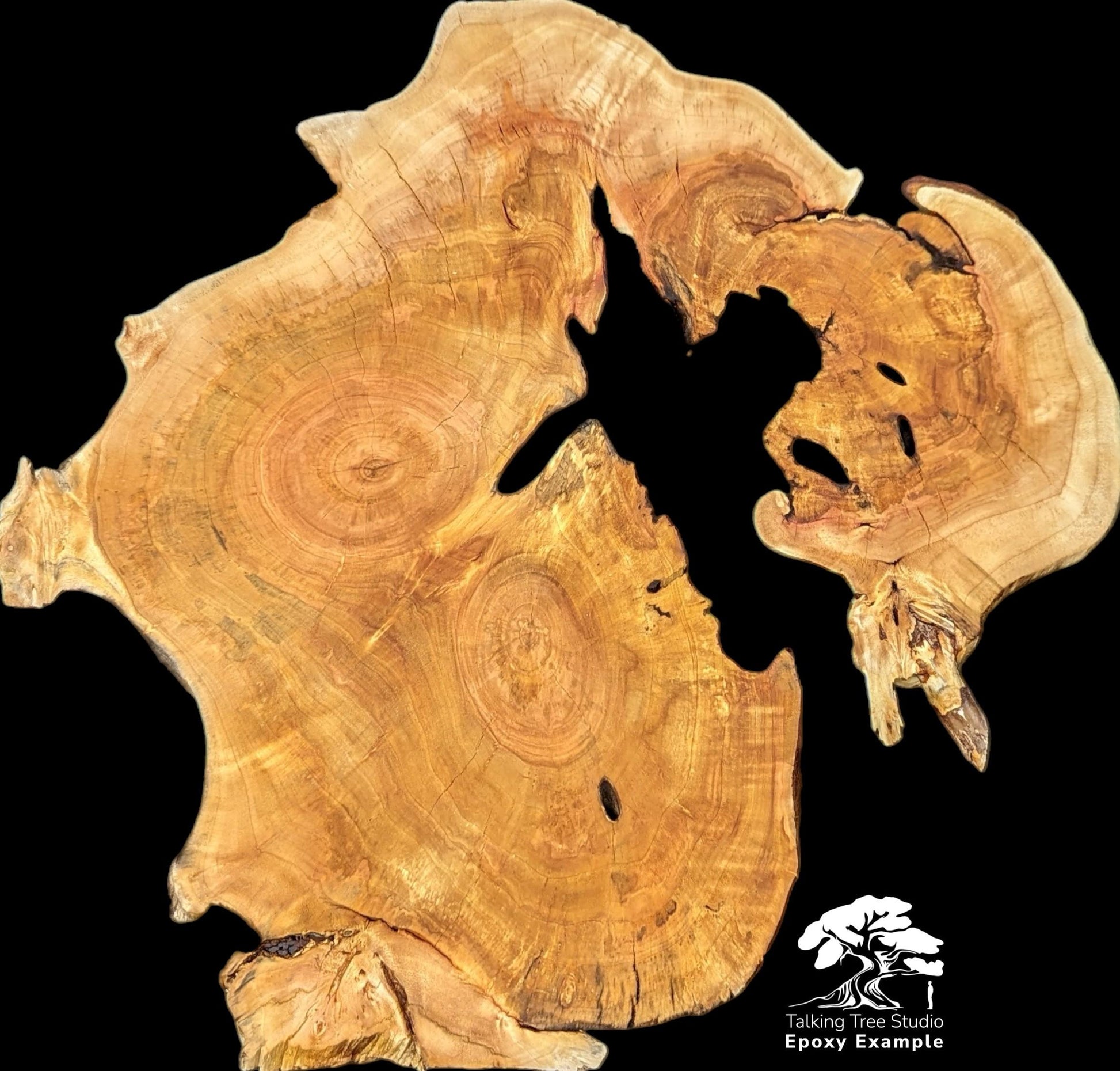 A light brown, irregular wood slice with prominent grain, dark voids, rough live edges. Includes logo.