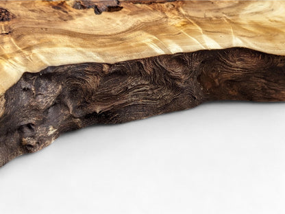 A natural wood slice edge features light brown wavy grain contrasting with a dark, deeply textured live edge.