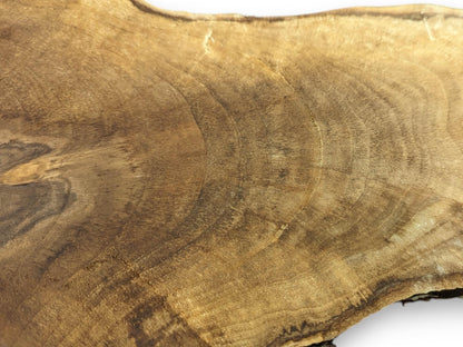 A natural wood slice surface with irregular brown grain patterns, distinct growth rings, and subtle natural cracks.