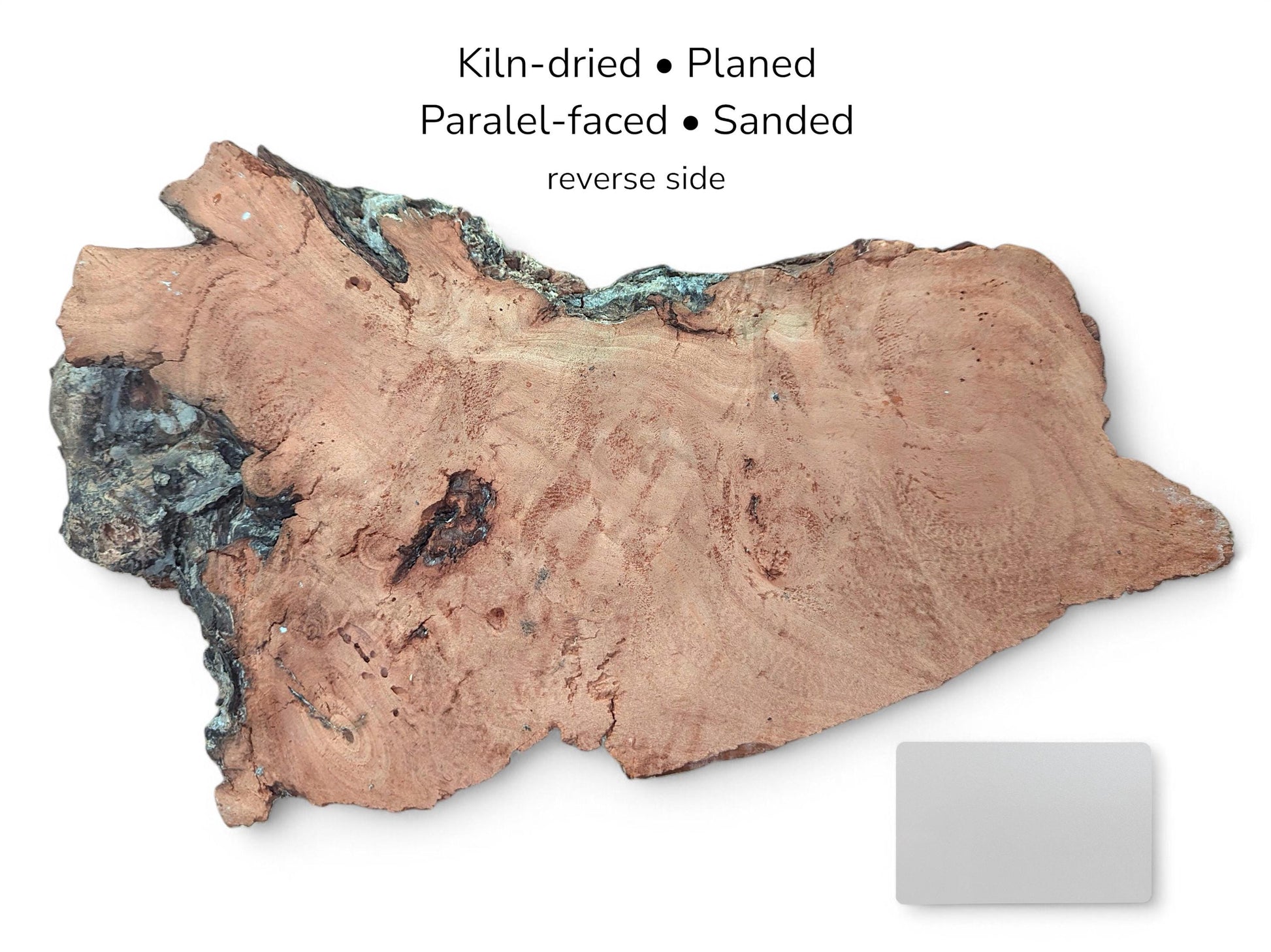 A reddish, sanded wood plank features a rugged, decaying live edge with dark, craggy sections.
