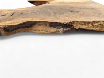 Light brown live edge walnut wood slice displaying natural grain, knots, and a textured, irregular side.