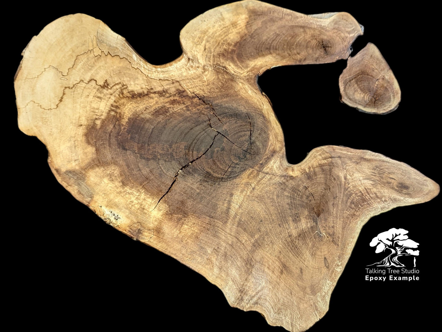 Organic walnut slab displaying blonde edges, dark center, prominent crack, and logo text on black background.
