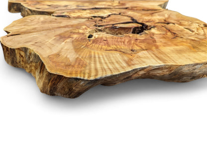 Organic-shaped live edge wood slice in golden-brown tones, displaying intricate grain patterns and natural voids.