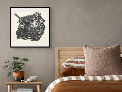 Detailed black and white woodcut print of an irregular tree root slice, framed in a bedroom.
